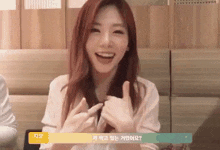 a woman with red hair is smiling and making a peace sign with her fingers