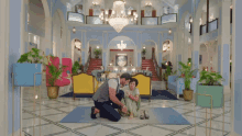a man kneeling down next to a woman in a room