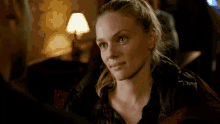 a woman in a plaid shirt looks at a man
