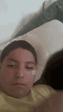 a boy with a bandage on his face is laying on a bed