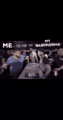 a group of people are standing around a table with the words `` my baby momma '' written on the bottom .
