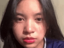 a close up of a girl 's face with long black hair and red lips .