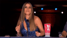 a woman sitting at a table with a sonic cup