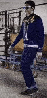 a man wearing sunglasses and a blue jacket is dancing
