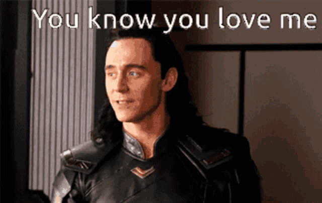 a man with long hair is standing in front of a sign that says you know you love me .