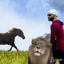 a man standing next to a lion while a horse runs by