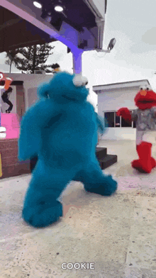 sesame street characters cookie monster and elmo are dancing on a stage