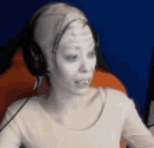 a woman with white paint on her face and headphones