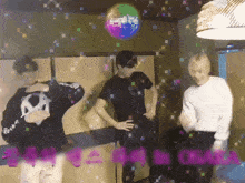 a group of young men are dancing in a room with a disco ball in the background ..