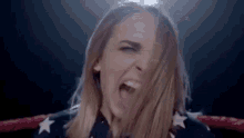 a woman is standing in a boxing ring with her mouth open .