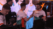 two men shaking hands in front of a screen that says heretics on it