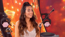 a woman is sitting in front of a microphone with the word cantando on the bottom