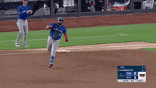 a blue jays baseball player runs to first base during a game