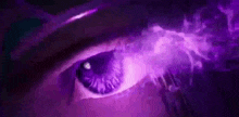 a close up of a person 's eye with a purple light shining through it .