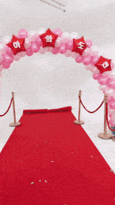 a red carpet is surrounded by pink and red balloons with the letters aa on them