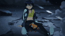 a girl in a yellow tank top sits on the ground in a dark room