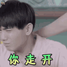 a man 's neck is being massaged by another person with chinese writing on it