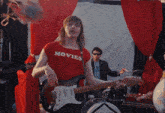 a man wearing a red shirt that says movies on it