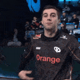 a man wearing a black shirt with the word orange on the front