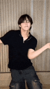 a young man is dancing in front of a window in a room .
