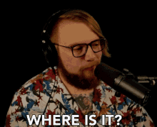 a man wearing glasses and headphones says " where is it "