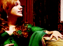 a woman in a green dress sits in a chair