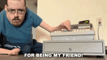 a man sitting on the floor next to a cash register with the words for being my friend