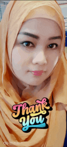 a woman wearing a hijab with a thank you sticker on it