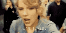 a close up of a woman 's face with the words `` i 'm tired '' written above her .