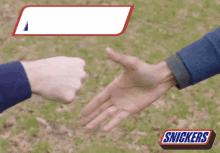 two men are shaking hands with a snickers bar in the foreground