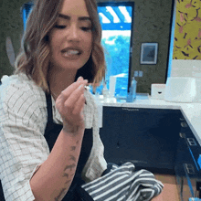 a woman in an apron is sitting in a kitchen