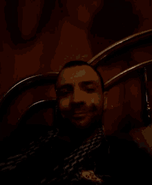 a man with a beard is laying on a bed and looking at the camera