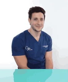 a man wearing a blue scrub top that says dr. khalid khalid on it