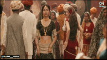 a woman in a crop top stands in a crowd of people with the words pranay_varma below her