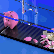 a pink piggy bank sits on a conveyor belt surrounded by broken pink coins