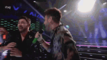 a man singing into a microphone with rtve written on the bottom