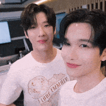 two young men are posing for a picture with one wearing a t-shirt that says i love emmaly