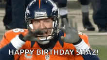 a football player is wearing a helmet and gloves and making a face .