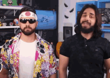 a man with a beard wearing sunglasses and a headband with a flag on it stands next to another man