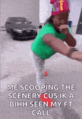a girl in a green shirt and pink hat is standing in front of a car