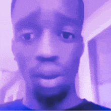 a blurry picture of a man 's face with a purple background .