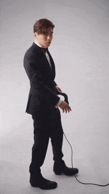 a man in a suit is standing next to a cord