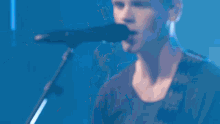 a man is singing into a microphone while another man plays a keyboard
