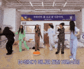 a group of women are dancing in front of a sign that says ' e ' on it