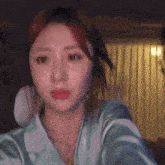 a woman is taking a selfie in a room while wearing a blue robe .