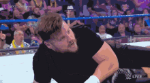 a man in a black shirt is in a wrestling ring with the words nxt championship on the bottom right