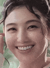 a close up of a woman 's face smiling with her teeth visible