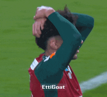 a soccer player wearing a green jersey that says ettigoat on it