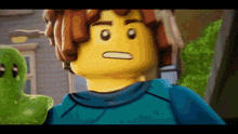 a close up of a lego man standing next to a green object