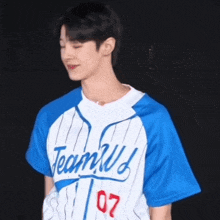 a young man wearing a blue and white baseball jersey with the word team u on it .